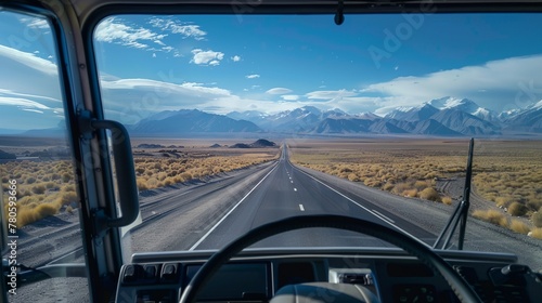 a truck driving down a highway with mountains in the background