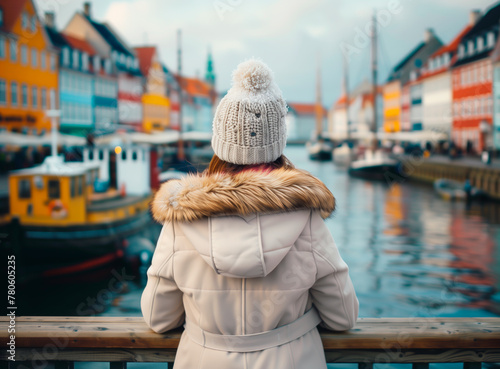 Woman overlooking colorful Nyhavn harbor in Copenhagen, Denmark, travel.