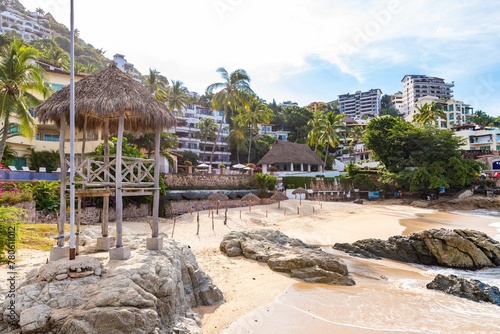 Aerial view of a tropical resort beach with palm trees and turquoise water in Puerto Vallarta