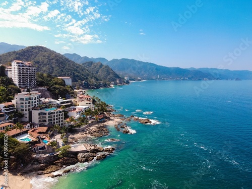 Aerial view of a tropical resort beach with palm trees and turquoise water in Puerto Vallarta