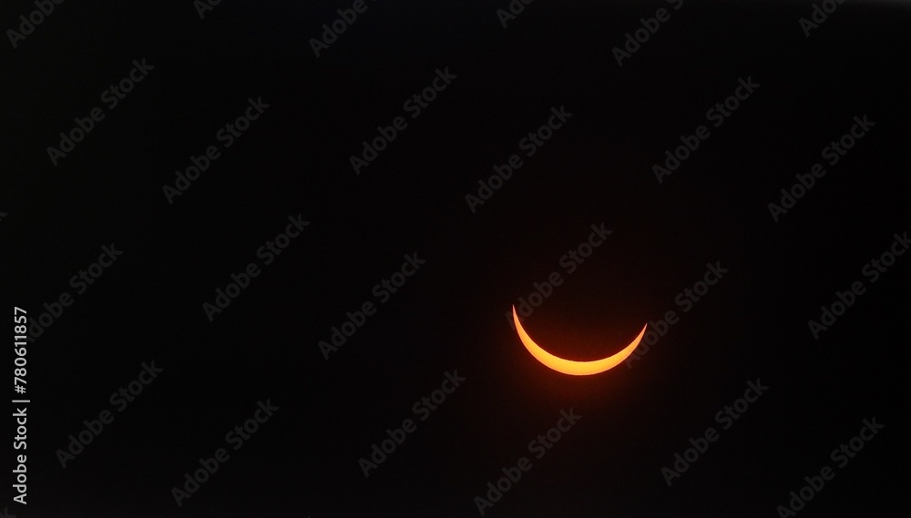 Solar eclipse with a glowing crescent in the dark sky Solar eclipse with a glowing crescent in the dark sky