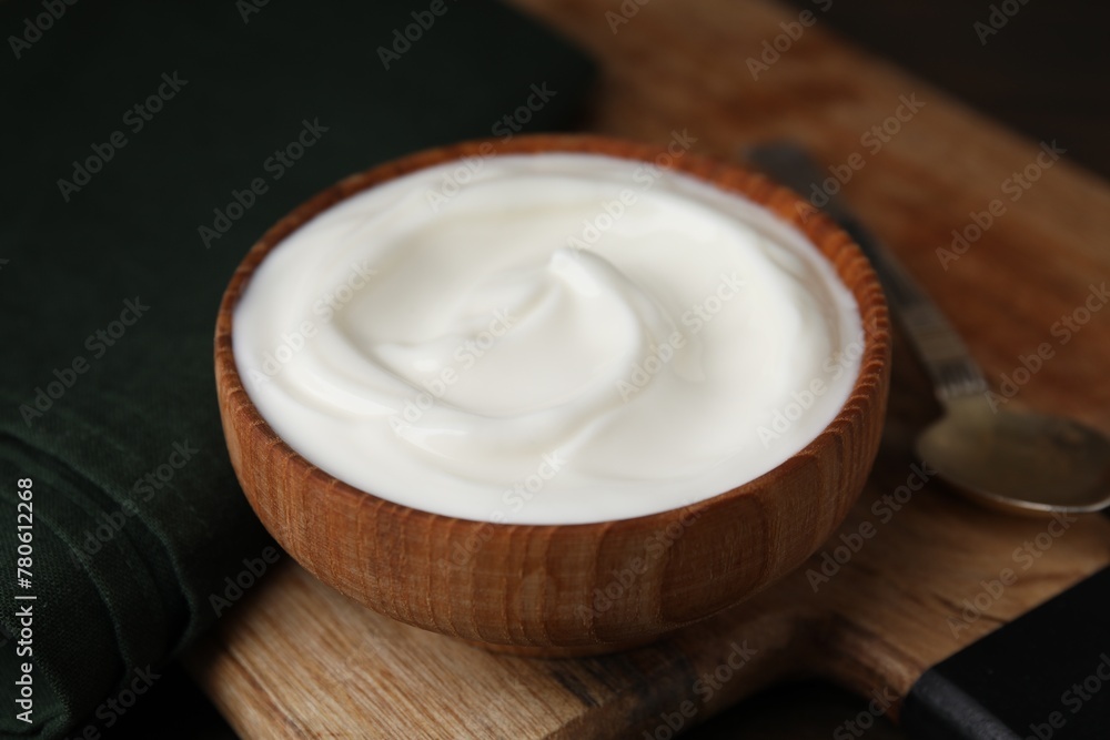 Delicious natural yogurt in bowl and spoon on table, closeup Delicious natural yogurt in bowl and spoon on table, closeup