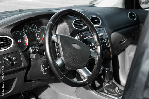 Black steering wheel and dashboard in car © New Africa