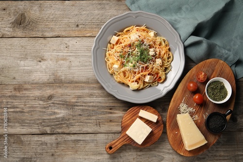 Vegetarian meal. Tasty pasta and fresh products on wooden table, flat lay. Space for text