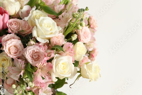 Beautiful bouquet of fresh flowers near white  closeup. Space for text