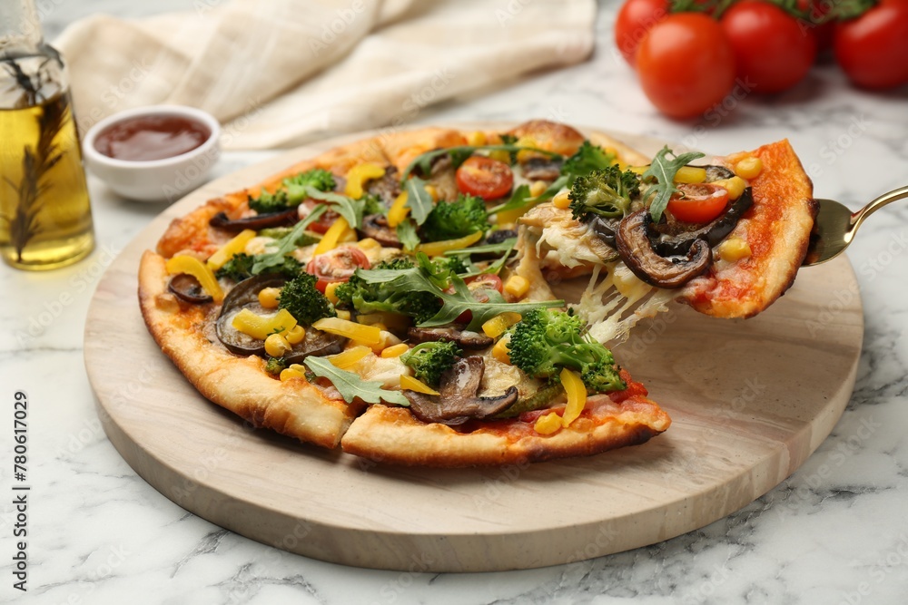 Taking piece of delicious vegetarian pizza at white marble table, closeup Taking piece of delicious vegetarian pizza at white marble table, closeup