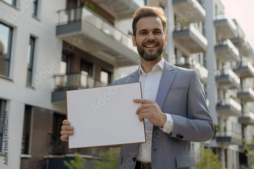 Handsome real estate agent holds a folder in hands.