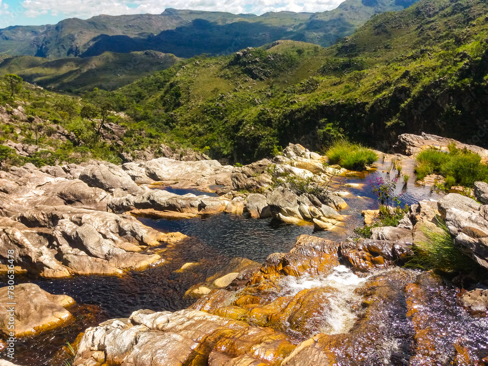 Naklejka premium Beautiful waterfall that has a mirror effect as it reflects the water on the stone walls on the banks. It is located in Serra do Cipó in Brazil