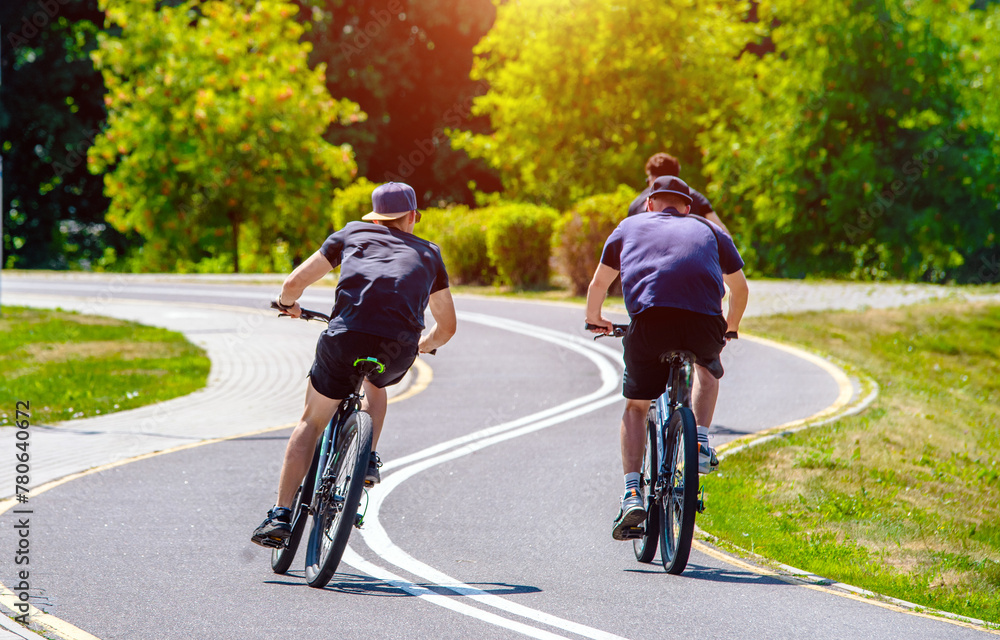 Fototapeta premium Cyclists ride on the bike path in the city Park 