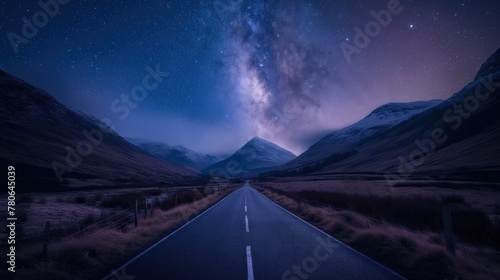 A road leading to distance in a mountain valley with a milky way photo