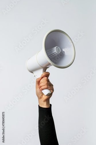 A hand holding a white megaphone on a white background. Copy space.