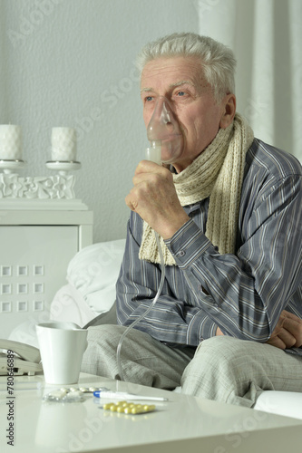 An elderly man is sick and uses an inhaler