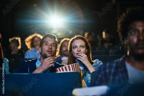 Young couple watching film in movie theater