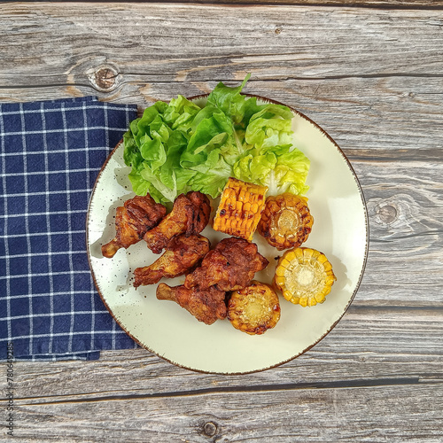 pilons de poulet et maïs grillé dans une assiette  © ALF photo