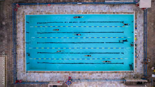 Several people training and exercising in a swimming pool, top view