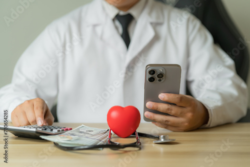 Male doctor uses smartphone to calculate health care costs.Cost control concept  health insurance