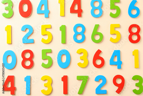 Colorful numbers on beige background, flat lay