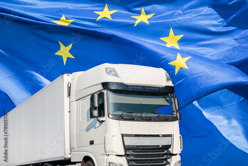 White transport truck in front of a waving European flag