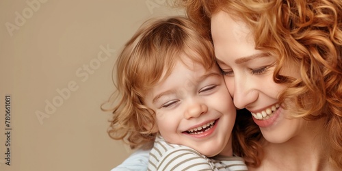 Joyful redhead mother embracing her toddler son. Concept of mother's love and mother's day celebration