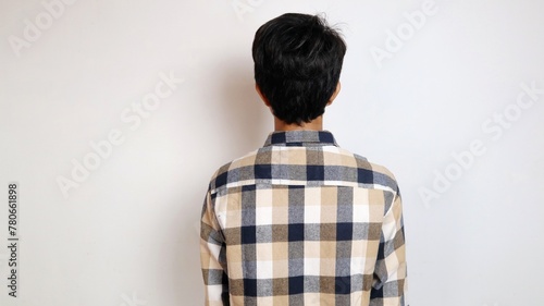 Back view of young Asian man posing facing backwards