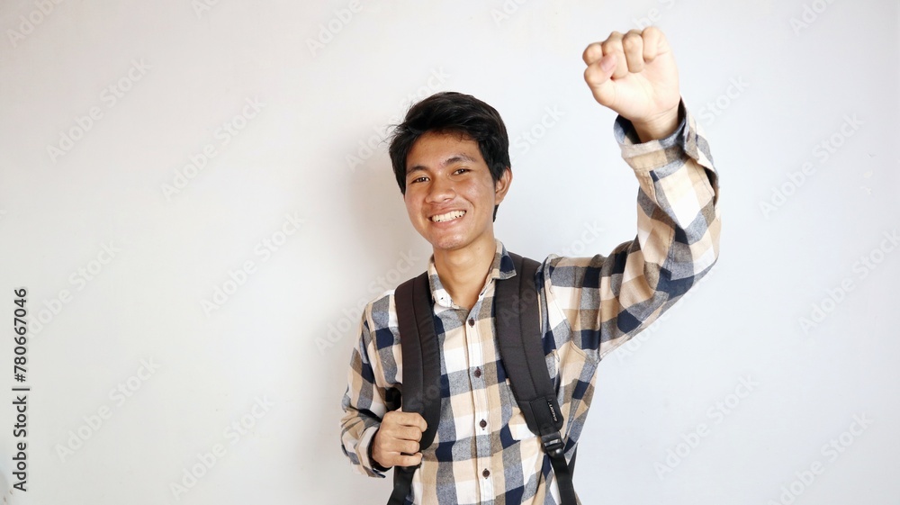 happy young asian man posing raising his hands enthusiastically and holding a bag on an isolated white background happy young asian man posing raising his hands enthusiastically and holding a bag on an isolated white background