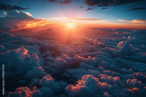 Breathtaking aerial perspective of a sunset peeking through soft cumulus clouds casting a warm glow