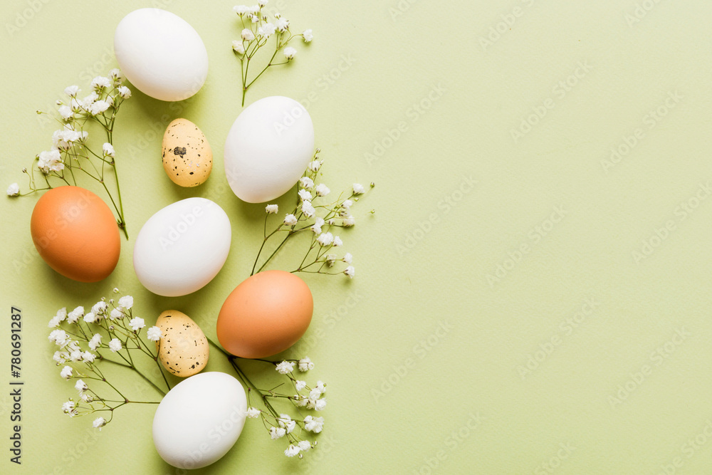 Happy Easter composition. Easter eggs on colored table with gypsophila. Natural dyed colorful eggs background top view with copy space