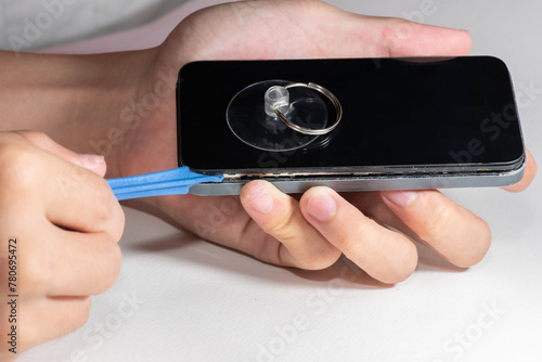 The smartphone was damages and need to repair which tools smartphone that stand isolated on white background by hands of repairman.	