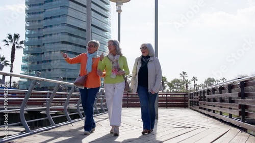 Mature group of tourists exploring the city. Three retired women walking outdoors.