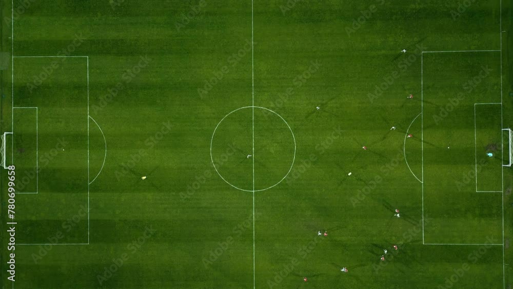 Aerial view of a soccer field in action, with players running, passing, and scoring goals.