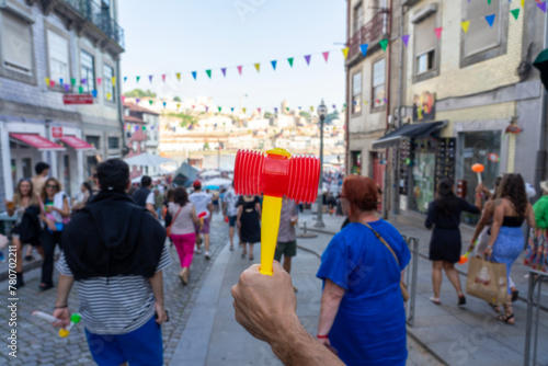 holding plastic hammer on the sao joao festival a funny event in Porto Portugal © Bernadett