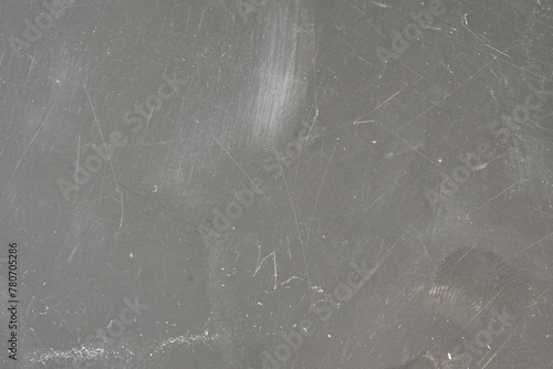 Close up view of scratches and marks on a flat light grey hard plastic material surface, plastic device case wear and tear, grunge worn damaged tech background texture, backdrop, nobody, no people
