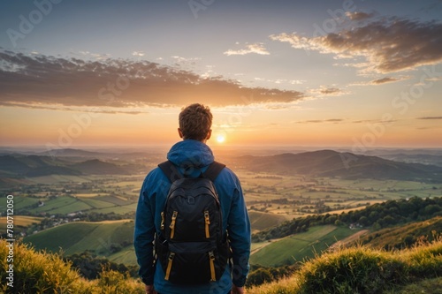 Man with backpack looking at view at sunset photo