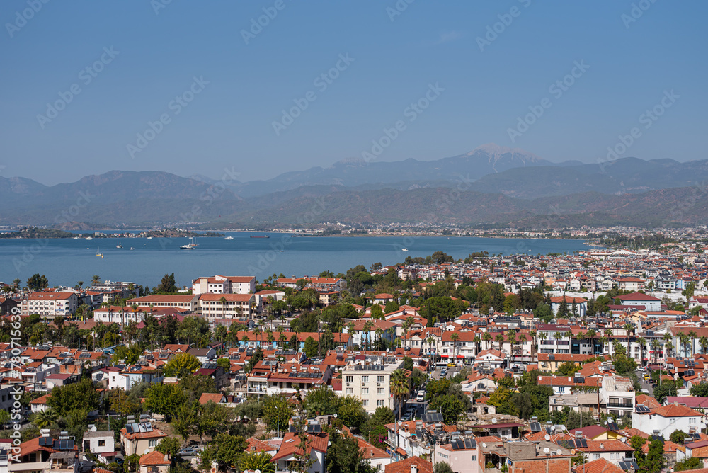 View of the city near the sea, a bay with yachts. From a bird's-eye view. Orange roofs. The Turkish city of Fethiye.