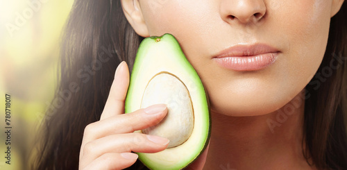 Close-up of avocado cut in half in woman's hand