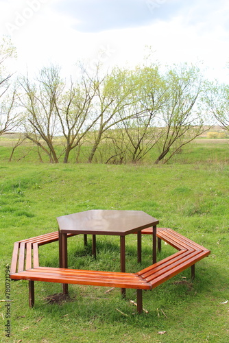A table and a bench in a grassy field