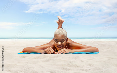 Happy young woman lying on sand beach, on a sunny day by the seaside, concept of a summer beach holiday, booking travel and resort accommodations, panoramic with a sky and sea horizon for copy space