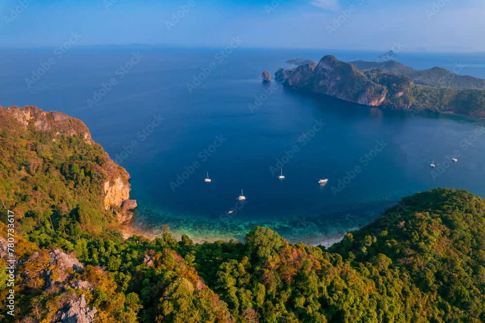 Aerial view Jungle with sunrise on Phi Phi with white yacht catamaran in Thailand. Concept trip Tourist boat in Thai travel.
