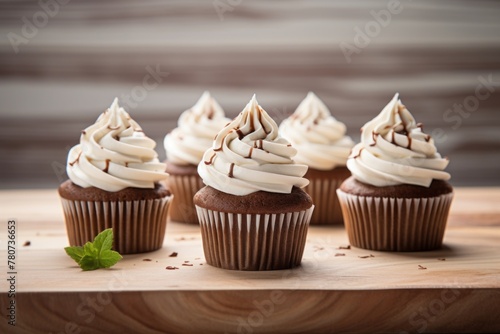 Refined cupcakes on a wooden board against a whitewashed wood background