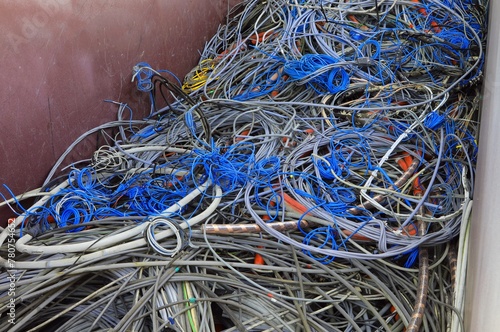 Discarded electrical wires pile up in the recyclable material container photo