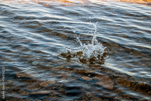 Fototapeta Naklejka Na Ścianę i Meble -  Stones fall into clean transparent water with splashes