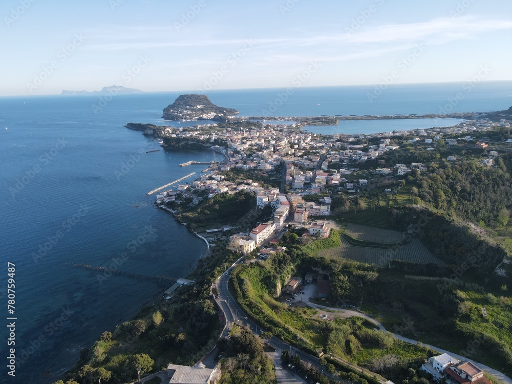 Explore the stunning coastline of a Southern Italian city Baia through breathtaking drone footage: crystal-clear waters, rugged cliffs, and colorful houses blend into an enchanting landscape