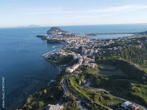 Explore the stunning coastline of a Southern Italian city Baia through breathtaking drone footage: crystal-clear waters, rugged cliffs, and colorful houses blend into an enchanting landscape