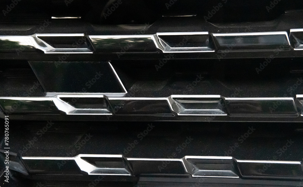 Close-Up of a Car's Black Grille with Chrome Accents