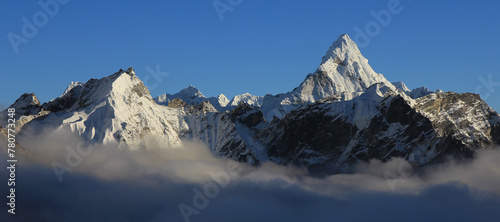 Mount Ama Dablam and other snow covered mountains reaching out of a sea of fog, Nepal. photo