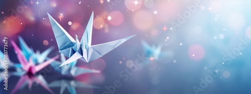 Origami paper bird in flight with a blurred background of stars and sparkles in blue and purple hues. photo