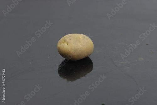 Potato and black background wit reflection 
