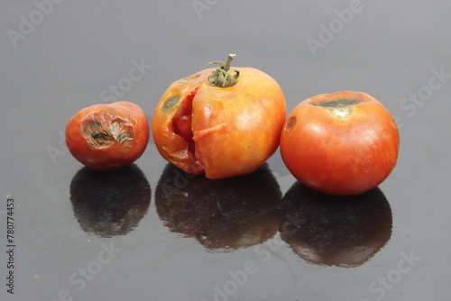 rotten tomatoes [ tree red rotten tomatoes with reflection ]