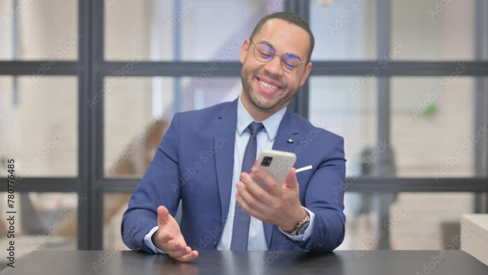 Mixed Race Businessman Celebrating Success on Phone in Office Mixed Race Businessman Celebrating Success on Phone in Office