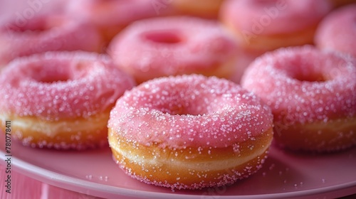  A tight shot of a plate filled with doughnuts, their surfaces glazed with pink icing, and adorned with colorful sprinkles